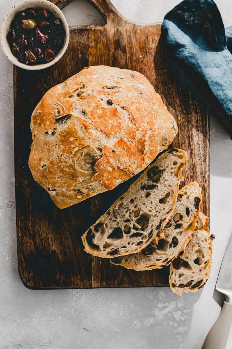 angeschnittenes olivenbrot auf einem holzbrett