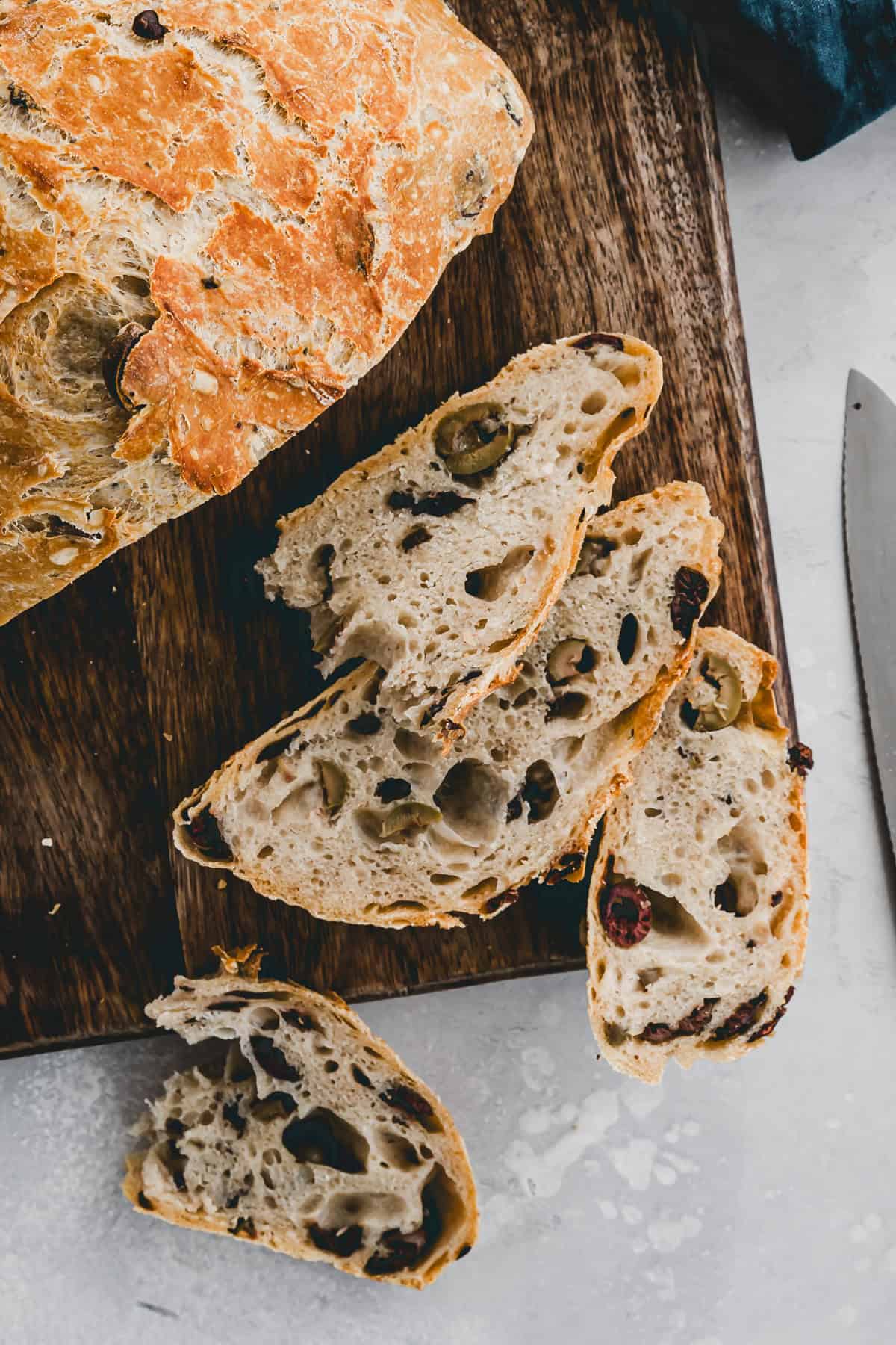 geschnittenes olivenbrot auf einem holzbrett