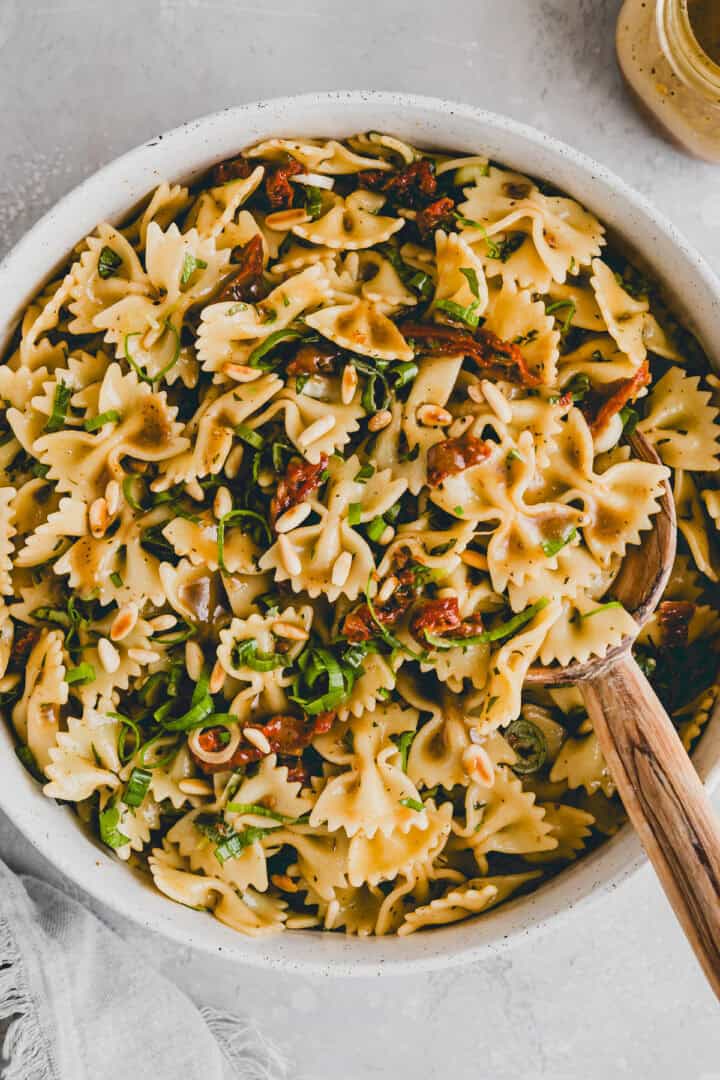 italienischer nudelsalat mit sonnengetrockneten tomaten in einer schüssel