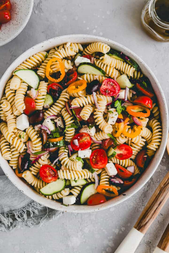 a salad bowl filled with greek pasta salad