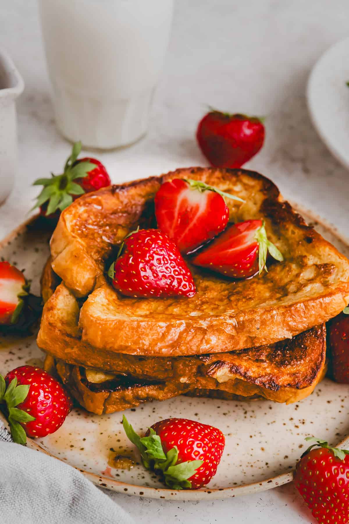 close up shot of french toast with brioche bread topped with strawberries