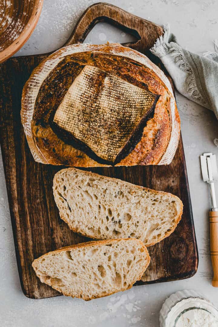 angeschnittenes sauerteigbrot auf einem holzbrett