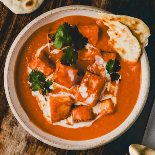 paneer butter masala in einer schüssel serviert mit naan brot