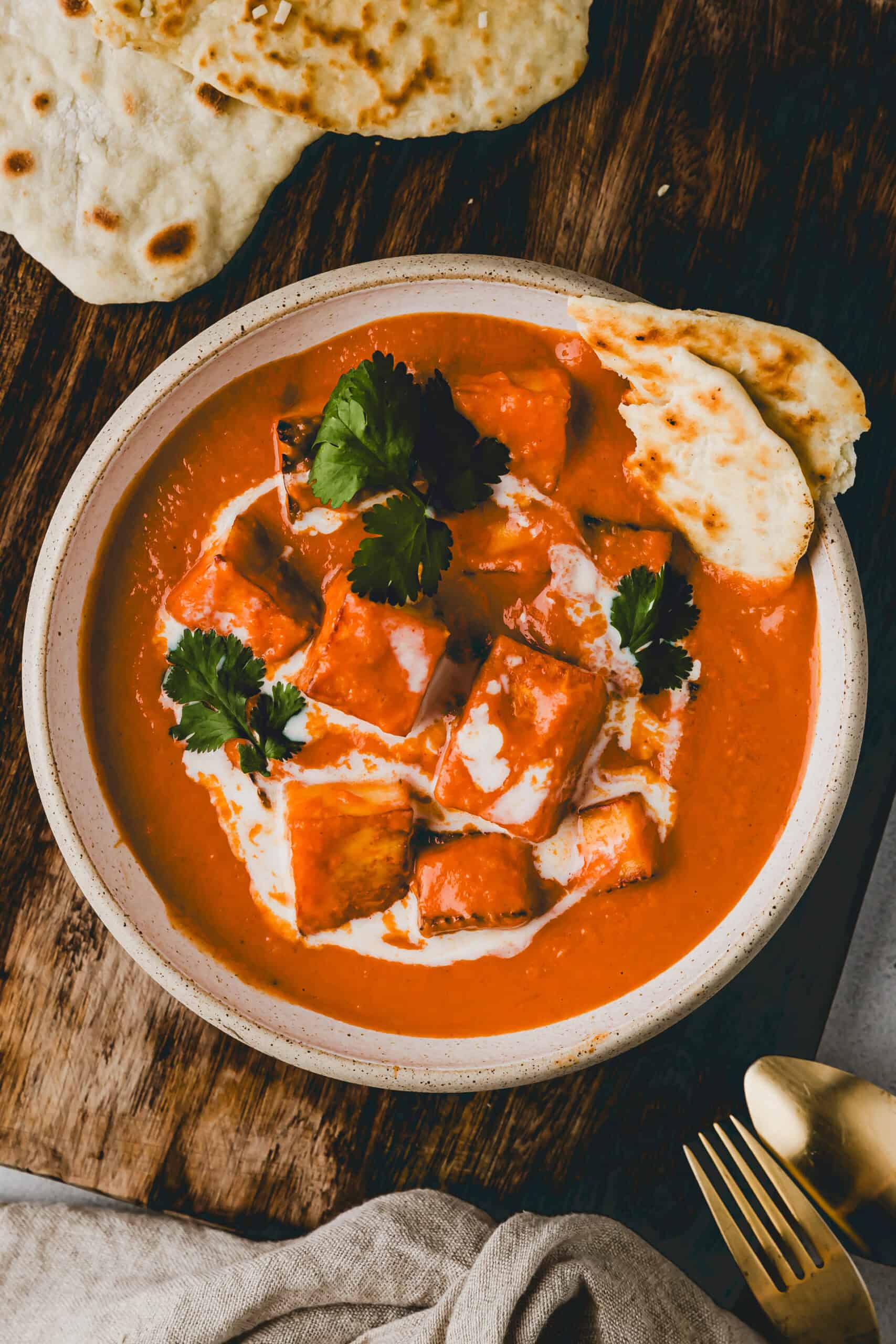 paneer butter masala in einer schüssel serviert mit naan brot
