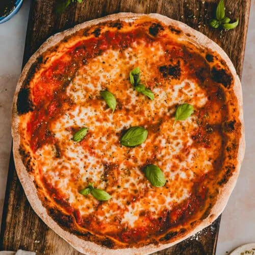 hausgemachte Pizza Margherita auf einem holzbrett serviert