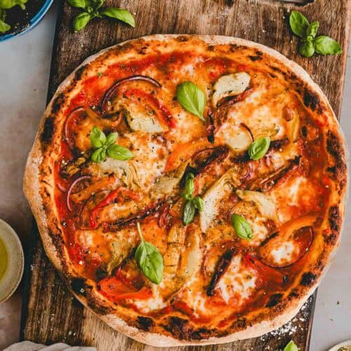 vegetarische pizza mit antipasti gemüse auf einem holzbrett