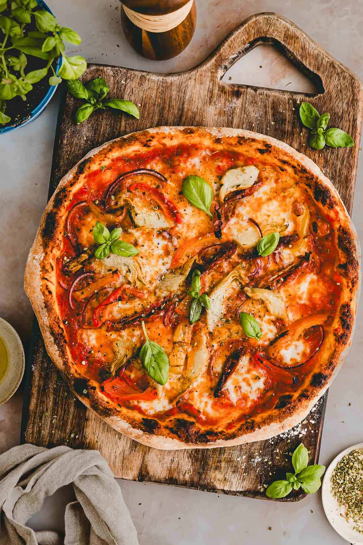 vegetarische pizza mit antipasti gemüse auf einem holzbrett