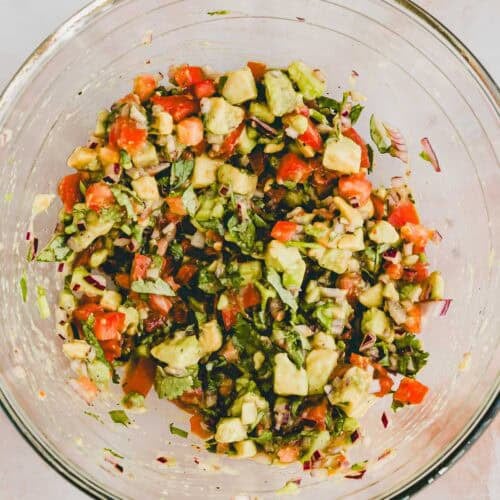 pico de gallo with avocado in a glass bowl