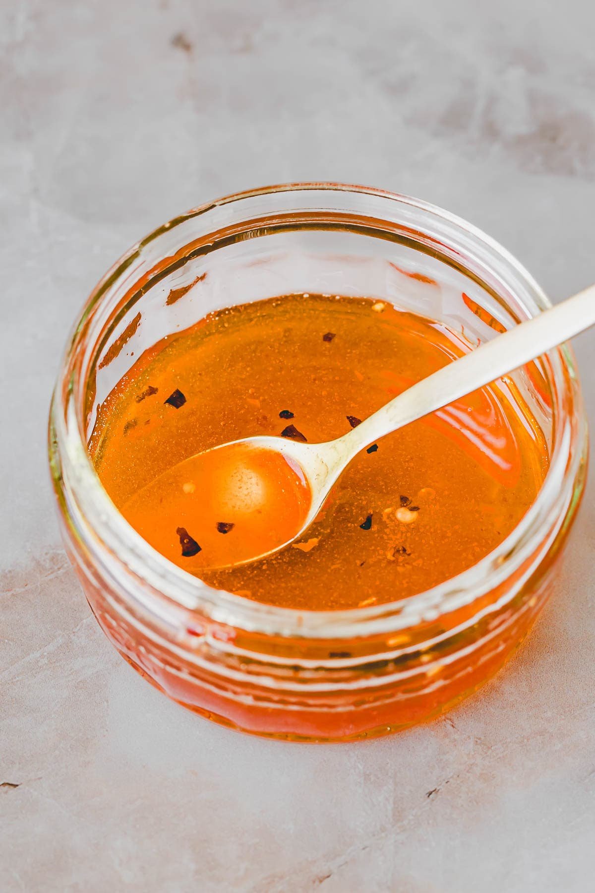 scharfer honig in einem glasschälchen mit einem goldenen teelöffel