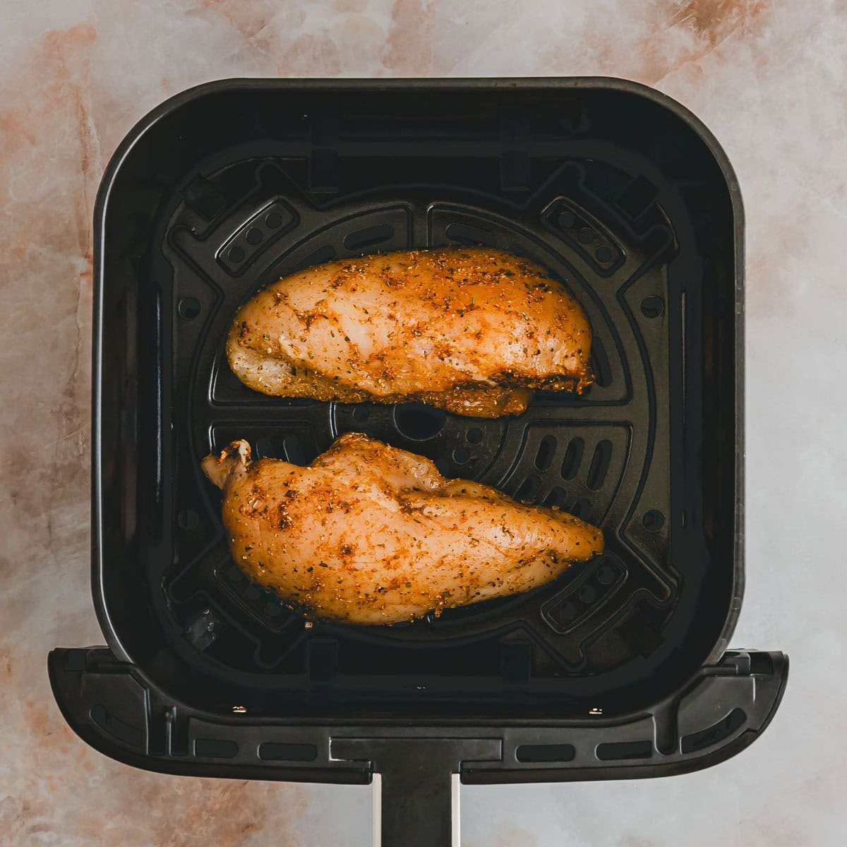 rohe marinierte hähnchenbrust in einem airfryer-basket