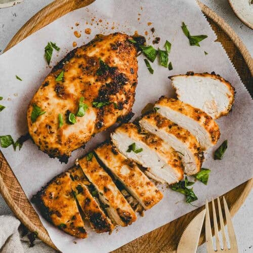 Hähnchenbrust im Airfryer zubereitet und aufgeschnitten auf einem holzteller