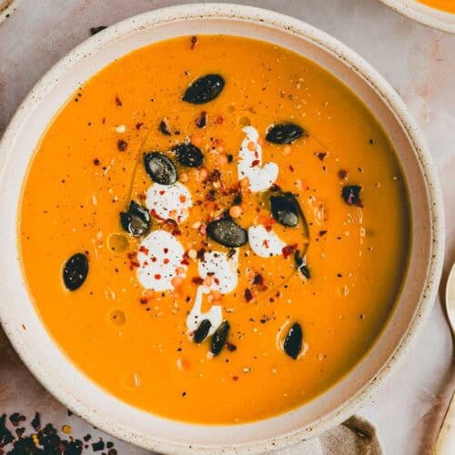Kürbis Linsen Suppe in einem Suppenteller dekoriert mit Kürbiskernen