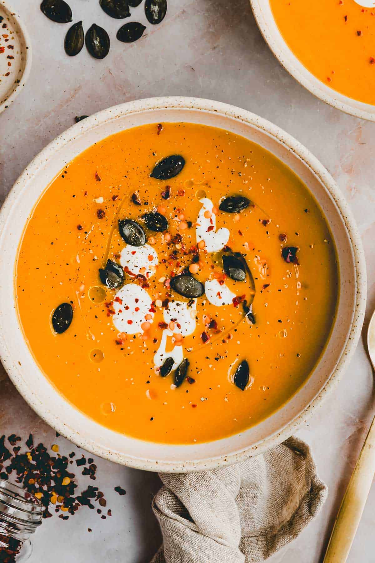 Kürbis Linsen Suppe in einem Suppenteller dekoriert mit Kürbiskernen