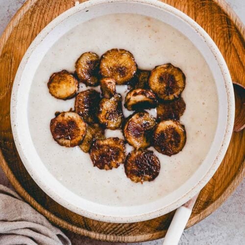 protein porridge mit proteinpulver und karamelisierten bananen in einer kleinen schüssel von oben fotografiert