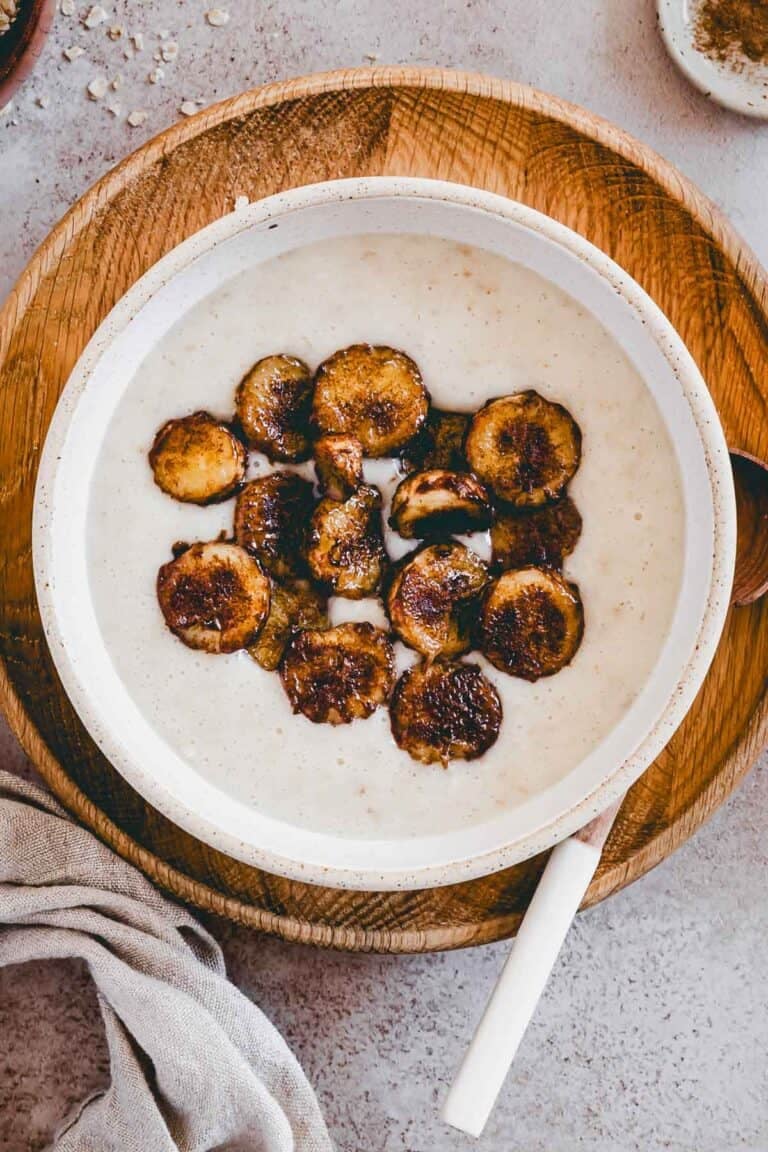protein porridge mit proteinpulver und karamelisierten bananen in einer kleinen schüssel von oben fotografiert