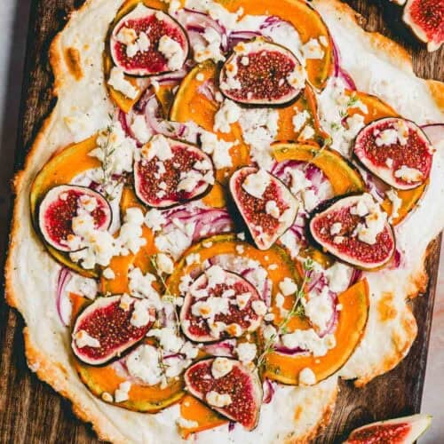 flammkuchen mit kürbis und feta auf einem holzbrett