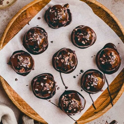 brownie protein balls auf einem mit backpapier belegten holzteller