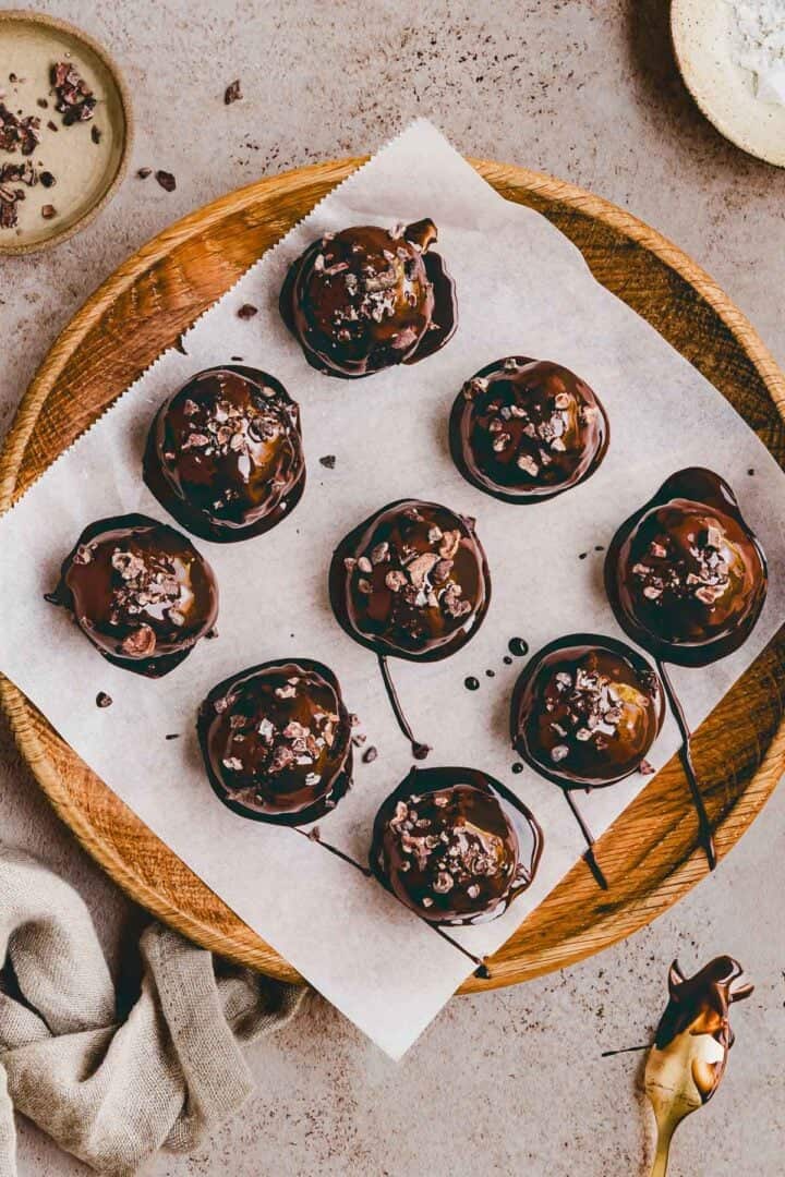 brownie protein balls auf einem mit backpapier belegten holzteller
