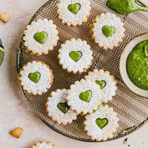 Plätzchen mit Pistaziencreme auf einem goldenen auskühlgitter präsentiert