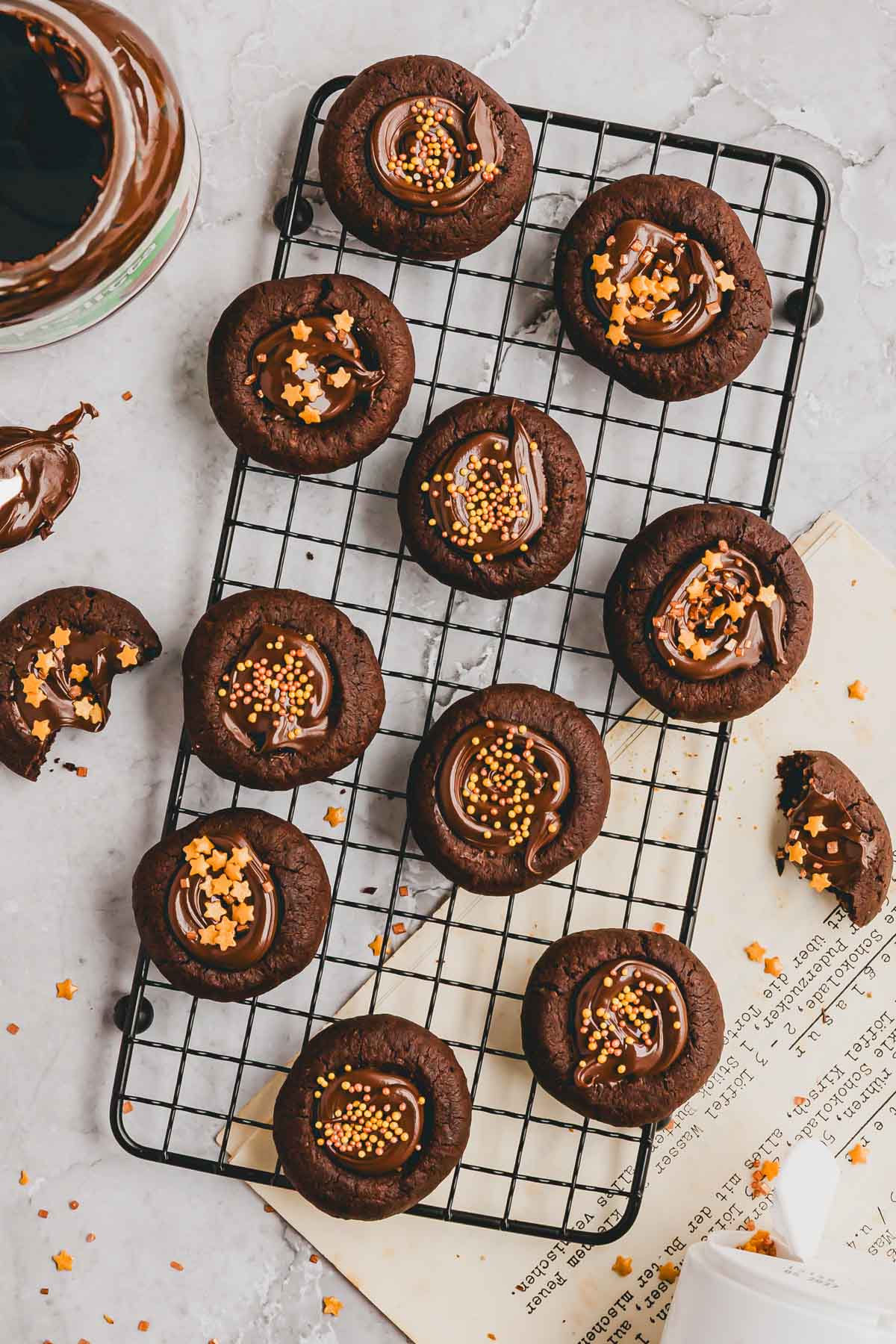 schoko engelsaugen gefüll mit nutella und mit streudekor verziert auf einem auskühlgitter