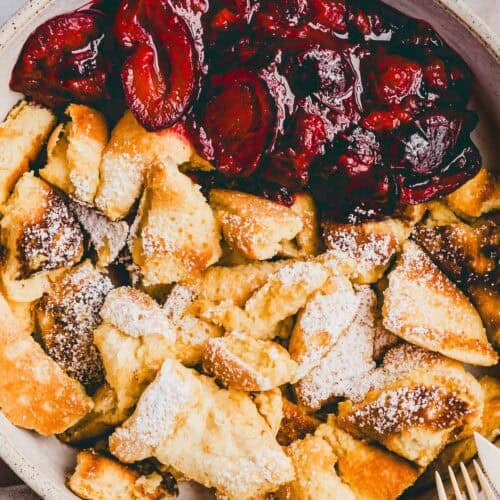 protein kaiserschmarrn mit warmen zwetschgen in einem teller serviert