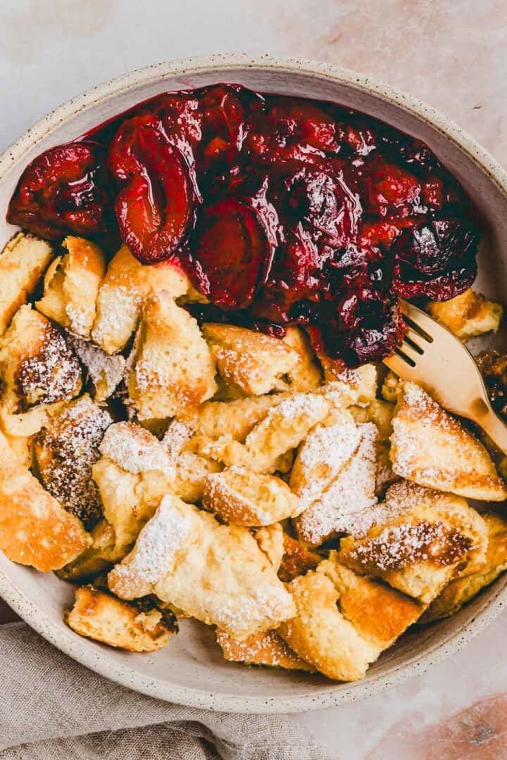 protein kaiserschmarrn mit warmen zwetschgen in einem teller serviert