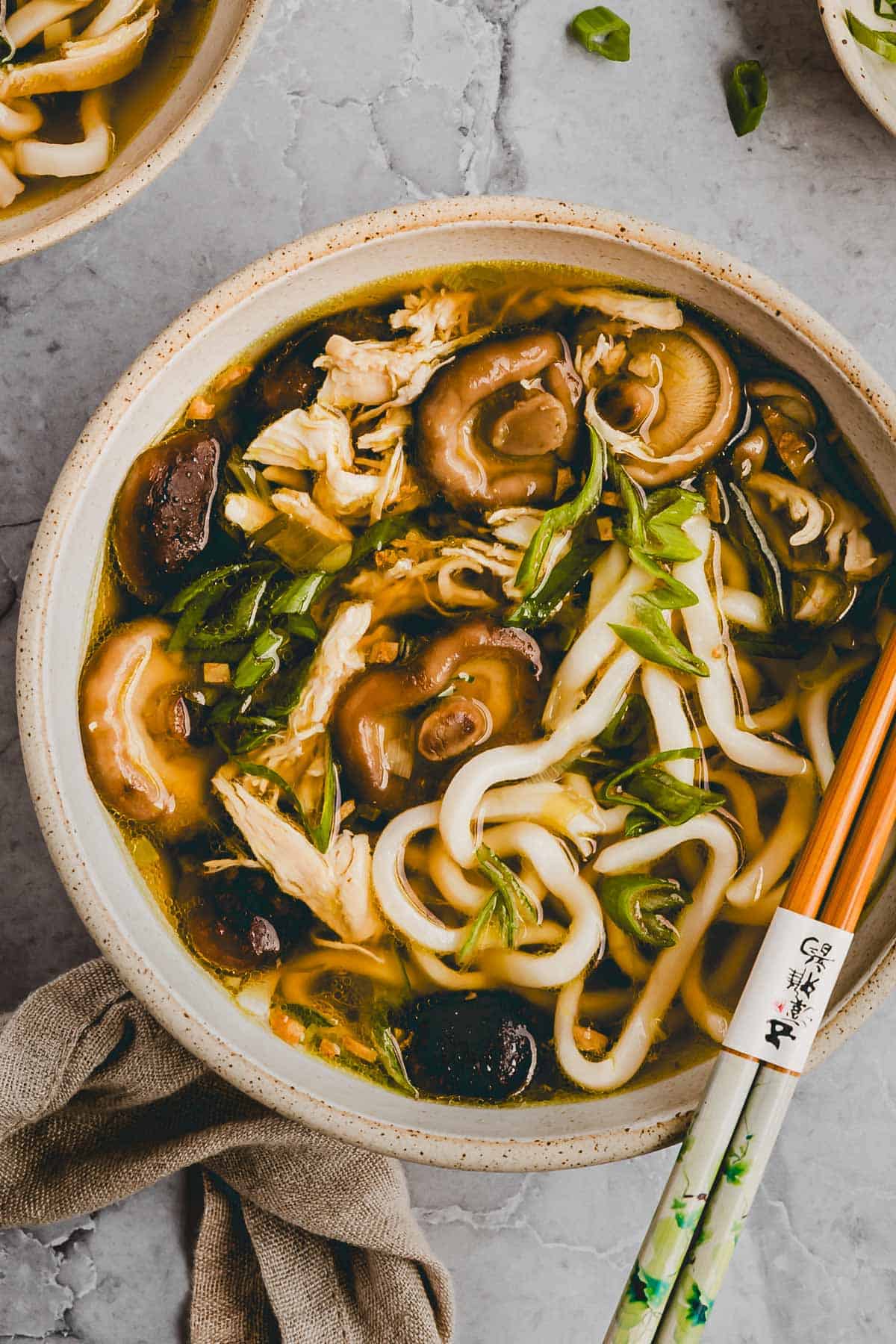 proteinreiche udon suppe mit hähnchen und shiitake in einer schüssel serviert