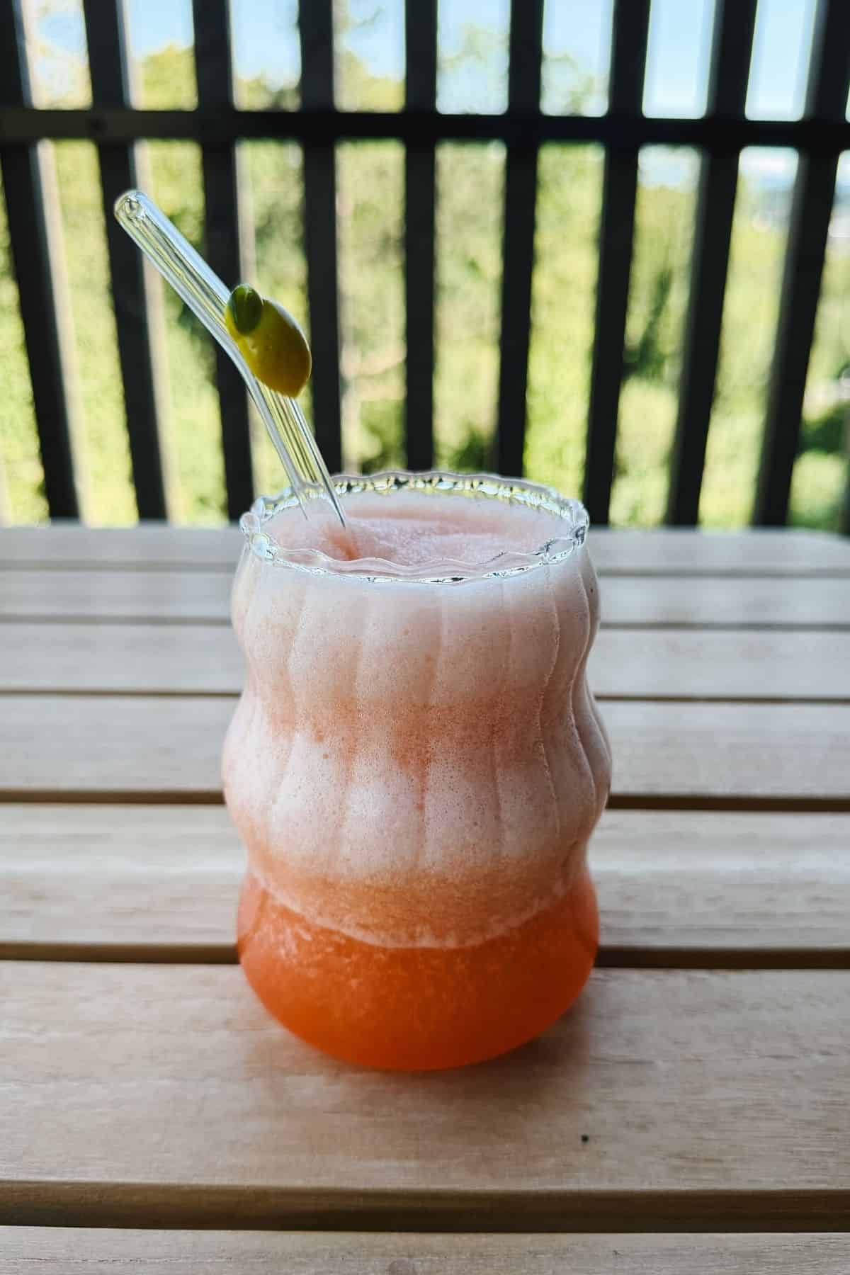 frozen aperol spritz auf dem balkon in einem glas serviert