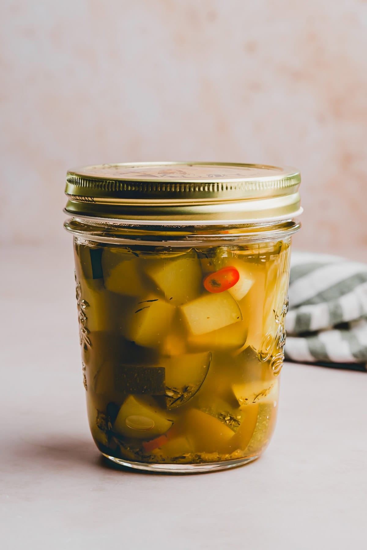 eingelegte zucchini in einem einmachglas von der seite fotografiert